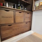 12. Our client chose to have their names engraved on the drawers. Of course, Brownie the dog has their own drawer as well! The blank drawer is ready for the next addition to the family.