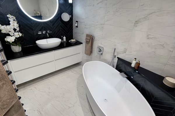 A beautiful room with a combination of black chevron tiles and crema delicato.