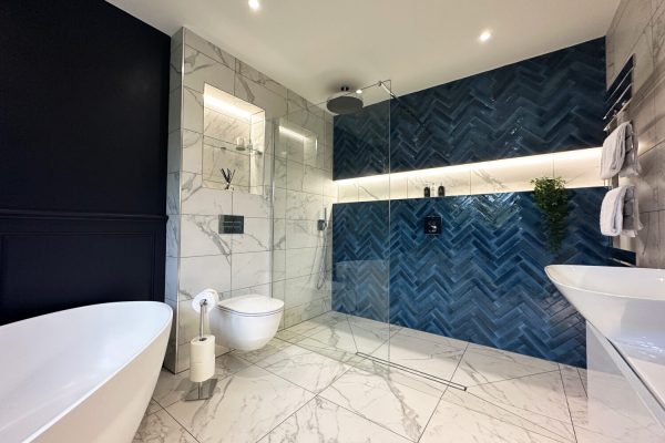 White marble effect tiles pair perfectly with the blue accents throughout the rest of the room.